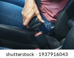 woman hand fastening a seatbelt in the car, Cropped image of a woman sitting in car and putting on her seat belt, Safe driving concept.