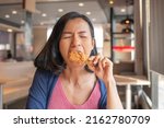 Asian beautiful woman enjoy eating with fried chicken. hungry woman looking, eating fried chicken, concept of delicious food, health care, eating habit, yummy fried chicken.
