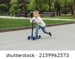 Child On A Scooter In The Park. ...