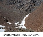 Small photo of Minimalistic mountain landscape with glacier on rocky hill. Scant snow on pass. Beautiful summer view to highland nature. Mountain of stones on high altitude.