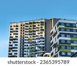 Small photo of Sunny evening light on the facade of a multi-storey building. Facade wall of a new modern residential building. Construction concept, residential quarter.