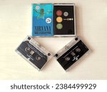 Small photo of Jakarta, Indonesia - Nov 6, 2023 : Original audio cassette tape. Universal Company production. Album from artists Blink182 and Nirvana. Selective focus. Macro mode. Cream brown as background.