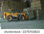 Small photo of Letniza, Lovech region, Bulgaria - 08.05.2020 : Farm workers loading bales of alfalfa with telescopic handler
