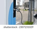 street, charging with electricity through cable, electric vehicle in European city, eMobility charging,energy accumulators, alternative energy development, technology and innovation