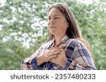 Small photo of excitedly woman 40 years old in plaid shirt holds to heart, sudden chest pain, closeup face with facial expression suffering, Ischemic heart disease, Arterial hypertension, Myocarditis or Arrhythmia