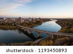 Aerial panoramic view of a bridge going over Saskatchewan River during a vibrant sunrise in the Fall Season. Taken in Saskatoon, SK, Canada.