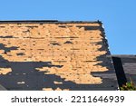 Small photo of Damaged house roof with missing shingles after hurricane Ian in Florida. Consequences of natural disaster
