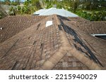 Small photo of Damaged house roof with missing shingles after hurricane Ian in Florida. Consequences of natural disaster