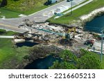 Aerial view of reconstruction of damaged road bridge destroyed by river after flood water washed away asphalt. Rebuilding of ruined transportation infrastructure