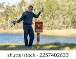 Operator is disappointed because he can not fly his quadcopter in national park no drone area. Man is unable to use his UAV near restriction notice sign