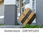 Small photo of Box with Amazon logo in front of house door. Ordered online christmas gifts in cardboard package on doormat. Amazon Prime priority delivery. E-commerce concept. Sarasota, USA - December 19, 2022.