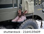Small photo of A pair of army boots hanging down from the old American troop carrier, Carentan, Manche, Normandy, France, Europe