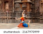 Small photo of Indian Dancer posing at temple. Odissi dance form. Dance of India