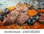 Small photo of Daub Provencal meat stew on plate on wooden background.