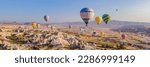 Small photo of BANNER, LONG FORMAT Colorful hot air balloons flying over at fairy chimneys valley in Nevsehir, Goreme, Cappadocia Turkey. Spectacular panoramic drone view of the underground city and ballooning