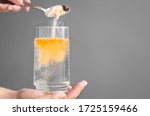 Orange fizzy powder and water glass with copy space. Healthy supplement. 
