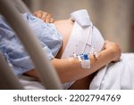 Small photo of A pregnant woman having contractions, waiting to give birth in the hospital.