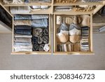 Small photo of Modern wardrobe with stylish women's clothing. Drawer with underwear, t-shirts, socks and shorts. The concept of storage and tidiness order.