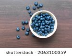 blueberries in a red bowl on... | Shutterstock . vector #2063100359