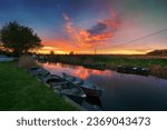 Small photo of Stunning sunset over boats moored on the river at West Somerton on Martham Broad in the Norfolk Broads