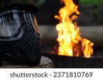 Small photo of Paintball mask infront of a campfire