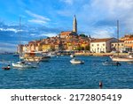Beautiful view of the harbor with boats, yachts and a old town buildings, Campanile of Saint Euphemia Church of Rovinj city against a blue sky in sunny day. Rovinj, Istria, Croatia