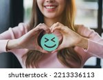 Small photo of Hands of woman holding happy smile face on wood block, user giving good feedback rating, think positive , customer review, assessment, of mental health day, Compliment Day, satisfaction concept.