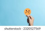 Small photo of Hand holding sad face negative emotion. emotional intelligence, balance emotion control, mental health assessment, bipolar and depression, mental health concept, personality, therapy healing split.