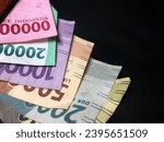 Small photo of Rupiah money in Wallet with Black background. IDR 100.000 IDR 20.000 IDR10.000 IDR5000 IDR 2000