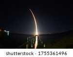 SpaceX rocket launch at night seen from Titusville, FL with destroyed dock in foreground