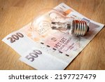Czech money CZK 700 and a light bulb, Concept of increasing energy and electricity prices in the Czech Republic