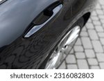 Automatic opening of a car door without a key. Keyless entry car door handle with keyless go touch sensor. Car door handle. Access button. Exterior design of a new electric luxury car.