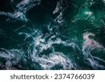 Small photo of Abstract background. Waves of water of the river and the sea meet each other during high tide and low tide. Whirlpools of the maelstrom of Saltstraumen, Nordland, Norway