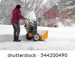 A woman cleans the winter snow with the snow mills