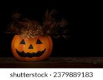 A spooky pumpkin on black...