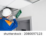 Small photo of master of emergency evacuation exits maintenance, repairs the warning system