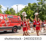 Small photo of Salt Lake City, Utah United States - June 4th 2023: University of Utah cheerleaders in the June 04th, 2023 Salt Lake City, (SLC), Utah Pride Parade US with the U of U Swoop Mobile Behind Bus them.