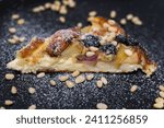 Small photo of sprinkle with powdered sugar delicious pie with pear and Brit cheese curd cheesecake nuts almonds and cashews on black snow-covered plate with sugar delicious appetizing dessert serving blueberries