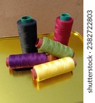 Small photo of sewing thread,sewing tools,colored thread,rainbow, black thread,yellow thread,leaf green,eggplant purple,skein of thread