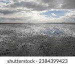 Small photo of North Sea Coast, Mudflats reflecting Clouds, Ebbing Tides