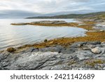 Small photo of Rocky shores of the Porsanger Fjord, Barents Sea, on a calm late summer evening, Finnmark, Norway