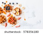 Traditional belgian waffles with fresh fruit and caramel on white background. Flat lay, top view, copy space.