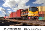 Small photo of Container Freight Train with cloudy sky.