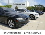 Small photo of FORT LAUDERDALE, FLORIDA/USA - MAY 31 2020 - Different color BMWs line up the parking lot in the afternoon sun with Service Center sign in the background at the dealership on 2601 S. Andrews Avenue