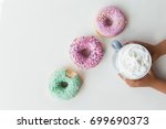 Colorful donuts and drink on the white background. Kids arms holding a cup of drink.Top view.Free space for text.