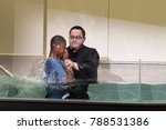 Small photo of Shepherd Church, Los Angeles, California, USA, January 7, 2017: A pastor baptize a young boy. Baptism is a Christian sacrament of admission and adoption, almost invariably with the use of water.