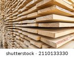 Perspective angle of wooden planks in close-up at a lumber warehouse. Background of boards.