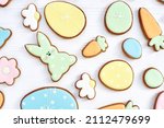 Gingerbread Cookies in shape of eggs and Easter bunny. Happy Easter holiday background concept. White background, top view, space for text. Holiday celebration decorations.