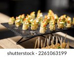 Small photo of light snacks for the holiday, catering. Various light snacks. Catering plate. Assortment of sandwiches on the buffet table. meat, fish, vegetable canapes.