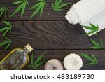 Leaves of cannabis, a bottle of hemp oil and tangles of thread on dark wooden surface. Hemp products. Agricultural technical culture. Top view
